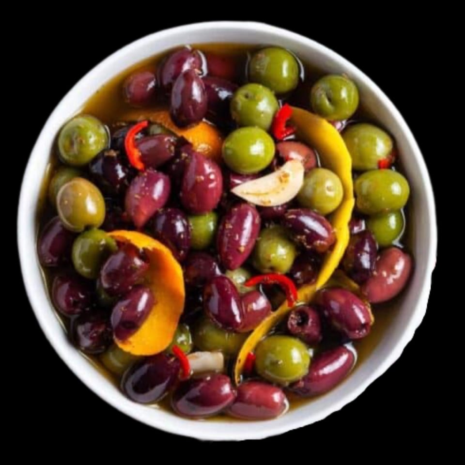 A white bowl filled with green and black olives, orange peel, and red chili in oil.